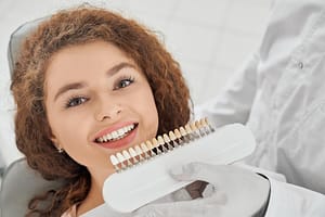 woman smiling while male dentist keeping teeth color range 651396 1397